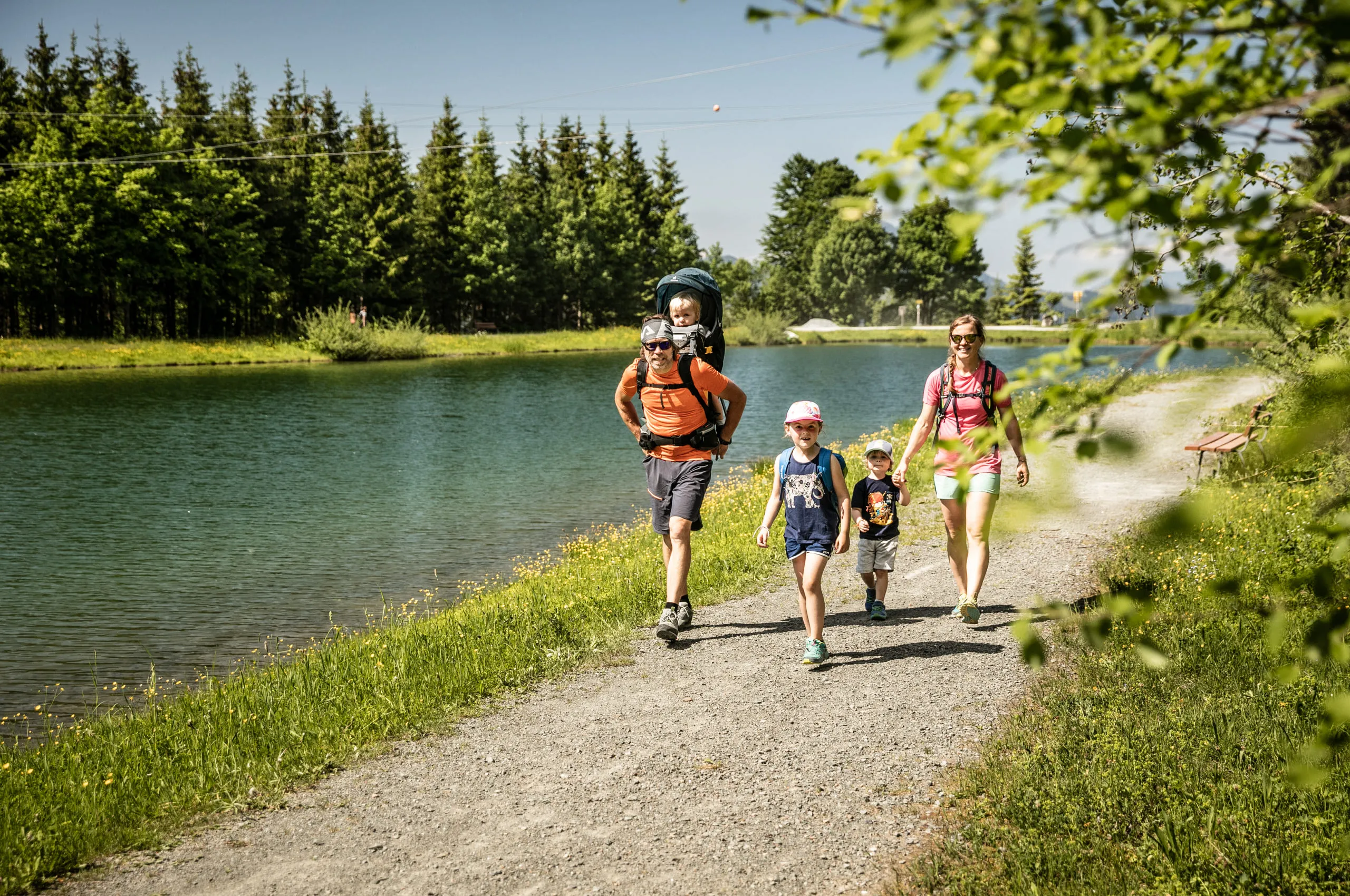 Familie beim Wandern am Ufer eines Teichs in St. Johann